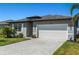The home has a large driveway, well maintained lawn, and a two-car garage at 16848 Cayo Key Dr, Port Charlotte, FL 33953