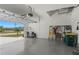 Spacious garage with an open door, epoxy flooring, and overhead storage racks at 16848 Cayo Key Dr, Port Charlotte, FL 33953