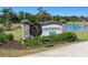 The Centennial Park sign with stone pillars and landscaping near a tranquil pond at 16848 Cayo Key Dr, Port Charlotte, FL 33953