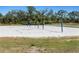 Outdoor sand volleyball court with nets, surrounded by lush green trees, perfect for recreation at 16848 Cayo Key Dr, Port Charlotte, FL 33953
