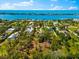 Scenic aerial view of the home near the waterfront and charming neighborhood, surrounded by trees and blue skies at 1785 Bayshore Dr, Englewood, FL 34223
