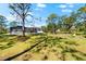 Large grassy backyard with firepit and seating, with the home and screened-in pool in the background at 1785 Bayshore Dr, Englewood, FL 34223