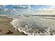 Waves crash on a sandy beach, creating a dynamic and scenic coastal view with natural beauty at 1785 Bayshore Dr, Englewood, FL 34223