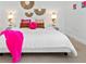 Close up of a bright bedroom featuring flamingo sconces, pink pillows and wall decor at 1785 Bayshore Dr, Englewood, FL 34223