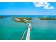 Scenic aerial view of a bridge leading to a coastal community with waterfront homes and boats at 1785 Bayshore Dr, Englewood, FL 34223