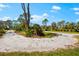 Gravel driveway, complemented by natural landscaping and an inviting neighborhood setting, exudes tranquility at 1785 Bayshore Dr, Englewood, FL 34223