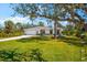 Charming single-story home featuring a well-manicured lawn, attached garage, and inviting curb appeal at 1785 Bayshore Dr, Englewood, FL 34223