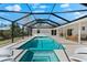 Inviting screened-in pool with chairs, a built-in spa and plenty of seating at 1785 Bayshore Dr, Englewood, FL 34223