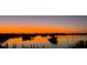 Beautiful sunset view over the water with small islands and a dock at 1785 Bayshore Dr, Englewood, FL 34223