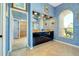 Bathroom with double vanities, framed mirrors, arched window view, tiled floors, and a walk-in shower at 1886 Killdeer Ct, Venice, FL 34293