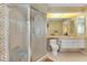 The bathroom features a shower with a glass door, toilet, and sink with white cabinets and decorative gold wallpaper at 1886 Killdeer Ct, Venice, FL 34293