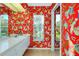 Bright bathroom featuring a large vanity with a sink and drawers, a window, and bold floral wallpaper at 1886 Killdeer Ct, Venice, FL 34293