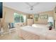 Cozy bedroom featuring two twin beds, soft lighting, neutral decor, and a large window with natural light at 1886 Killdeer Ct, Venice, FL 34293