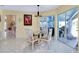 Bright dining area with glass table, stylish chairs, and access to the outdoor patio at 1886 Killdeer Ct, Venice, FL 34293