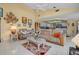 Bright living room with tile flooring and a leather sofa, leading into the kitchen at 1886 Killdeer Ct, Venice, FL 34293