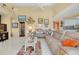 Living room featuring light-colored walls, tile flooring, and a comfortable leather sofa at 1886 Killdeer Ct, Venice, FL 34293