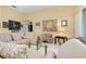 Bright living room featuring a glass coffee table, patterned chairs, and unique wall art at 1886 Killdeer Ct, Venice, FL 34293