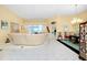 Spacious living room with tile flooring, modern sofa, and view into the formal dining area at 1886 Killdeer Ct, Venice, FL 34293