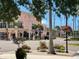 Charming street view showcasing vibrant flowers, trees, boutiques, and a relaxed pedestrian crossing at 1886 Killdeer Ct, Venice, FL 34293