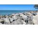 Scenic waterfront view with large rocks along the shoreline, offering a peaceful and natural setting at 1886 Killdeer Ct, Venice, FL 34293