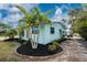 Side view of the light blue house with well manicured plants and black mulch, next to a driveway at 1971 Pennsylvania Ave, Englewood, FL 34224