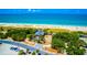 Aerial view of a beachside building with a boardwalk, surrounded by trees and ocean, highlighting its prime location at 201 Cavallini Dr, Nokomis, FL 34275