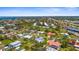 An overhead view showcasing a single-Gathering home with a pool and firepit in a lush, green residential neighborhood at 201 Cavallini Dr, Nokomis, FL 34275