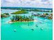 Aerial view of a stunning waterfront community with multiple islands and boats on the tranquil, clear water at 201 Cavallini Dr, Nokomis, FL 34275