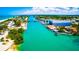 Aerial view showcasing the waterway, boat docks, and various buildings, including a boat storage facility in a coastal neighborhood at 201 Cavallini Dr, Nokomis, FL 34275