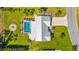 An aerial view of a home showcasing a pool, fire pit, and lush green landscaping at 201 Cavallini Dr, Nokomis, FL 34275