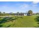 The spacious backyard has a manicured lawn, a circular fire pit, and access to a screened-in pool area for outdoor enjoyment at 201 Cavallini Dr, Nokomis, FL 34275
