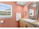 Bathroom with wood vanity, and tiled countertop, offering plenty of natural light from a window with blinds at 201 Cavallini Dr, Nokomis, FL 34275