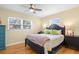 Cozy bedroom with natural light, featuring hardwood floors, ceiling fan, and comfortable decor with ample closet space at 201 Cavallini Dr, Nokomis, FL 34275