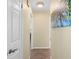Well-lit hallway with ceramic tile floors and neutral paint, providing access to different areas of the home at 201 Cavallini Dr, Nokomis, FL 34275