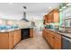 Spacious kitchen featuring wood cabinets, granite countertops, stainless steel range hood, and an open layout to the living area at 201 Cavallini Dr, Nokomis, FL 34275