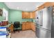 Bright eat-in kitchen with stainless steel appliances, natural wood cabinets, granite countertops, and dedicated desk area at 201 Cavallini Dr, Nokomis, FL 34275