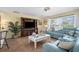 Comfortable living room featuring a large TV, natural light, and a cozy blue sectional at 201 Cavallini Dr, Nokomis, FL 34275