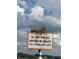 An osprey nests atop a Manatee Zone sign with a blue sky filled with puffy white clouds in the background at 201 Cavallini Dr, Nokomis, FL 34275