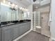 Bathroom featuring double sinks, granite countertops, and a glass block shower at 206 Bella Vista Ter # 29A, Nokomis, FL 34275