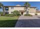 Inviting two-story home featuring a brick driveway, well-manicured lawn, and verdant landscaping at 206 Bella Vista Ter # 29A, Nokomis, FL 34275