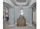 Elegant foyer featuring tray ceilings, decorative chandelier, arched doorways and travertine floors at 206 Bella Vista Ter # 29A, Nokomis, FL 34275