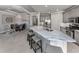 A kitchen with gray cabinets, stainless appliances, and a marble island open to the dining area at 206 Bella Vista Ter # 29A, Nokomis, FL 34275