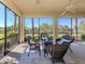 Enclosed patio features wicker seating with an outdoor view of tropical greenery and sunny skies at 206 Bella Vista Ter # 29A, Nokomis, FL 34275