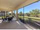 Enclosed patio with a ceiling fan, seating, and view of an expansive lawn with a scenic view at 206 Bella Vista Ter # 29A, Nokomis, FL 34275
