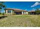 Well-maintained backyard showcasing lush green grass, a covered patio, and the home's exterior, creating an inviting outdoor space at 20794 Valprato Ct, Venice, FL 34293