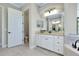 Bright bathroom featuring a soaking tub, tiled floor, vanity with granite top, and toilet room at 20794 Valprato Ct, Venice, FL 34293