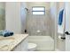 Well-lit bathroom featuring a tiled shower, window, granite counter, and neutral wall color at 20794 Valprato Ct, Venice, FL 34293