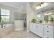 Bright bathroom featuring a soaking tub, tiled floor, vanity with granite top, and walk-in shower at 20794 Valprato Ct, Venice, FL 34293