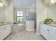 Bright bathroom featuring a soaking tub, tiled floor, double sinks and neutral color palette at 20794 Valprato Ct, Venice, FL 34293