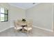 A sunlit dining area features a round table with four chairs and a window in the corner at 20794 Valprato Ct, Venice, FL 34293